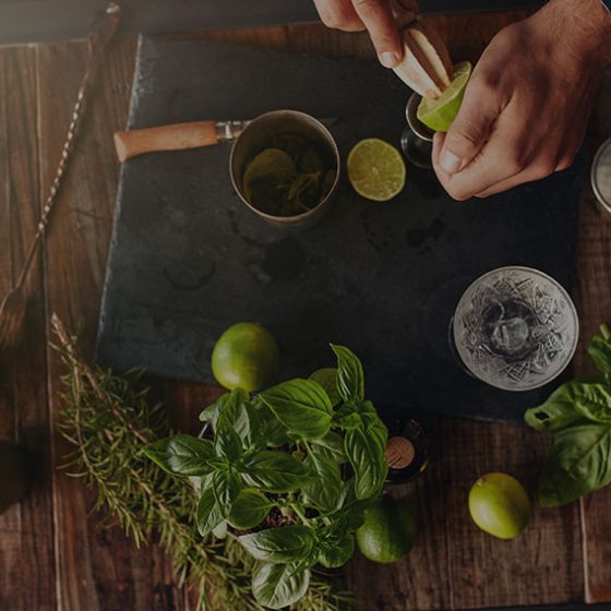 birds eye view of man making cocktails with fresh herbs