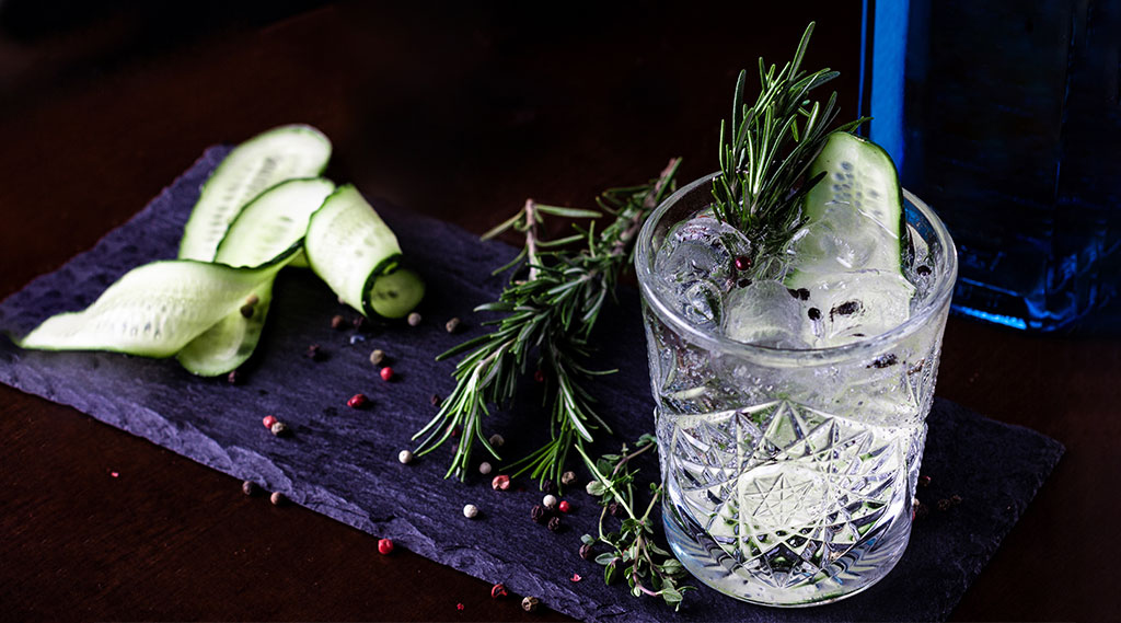 cocktail with fresh rosemary, peppercorns and cucumber