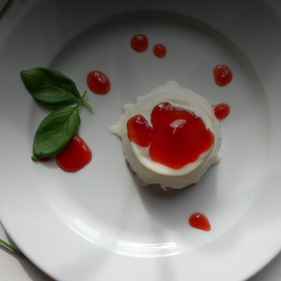 panna cotta on a plate with fresh basil