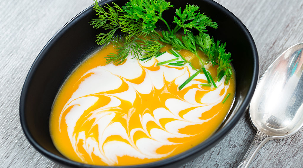 Spicy pumpkin soup puree with ginger and herbs
