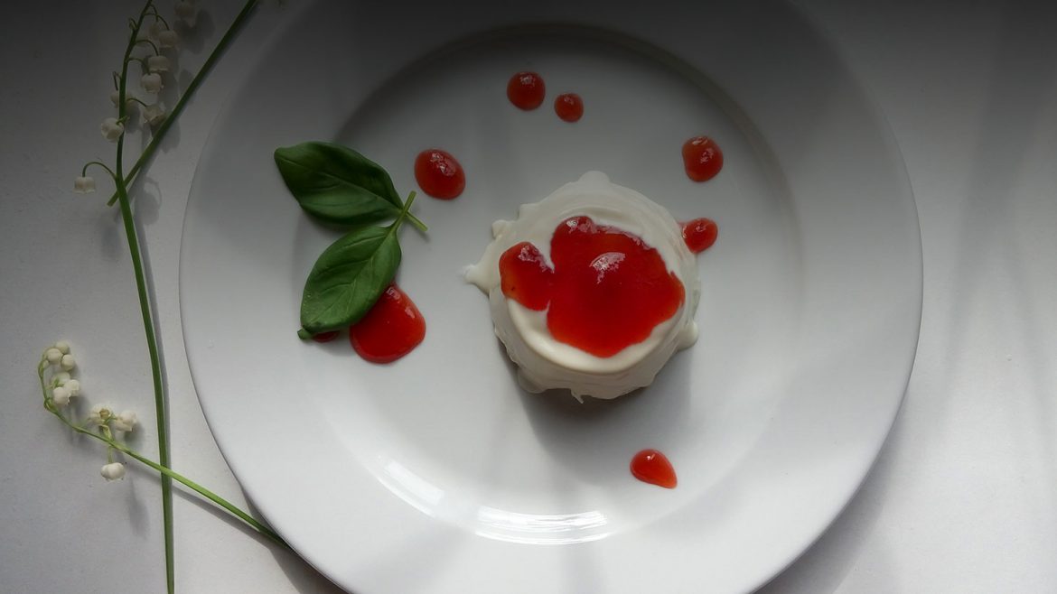 panna cotta on a plate with fresh basil